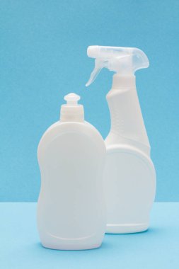 Mavi arka planda bulaşık deterjanı şişeleri.
