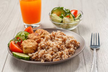 Karabuğday, kızarmış et pirzola ve taze salatalık ve domates parçaları ile Plaka