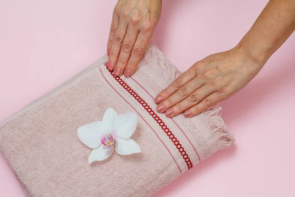 ピンクの背景に花と柔らかいテリータオル. — ストック写真