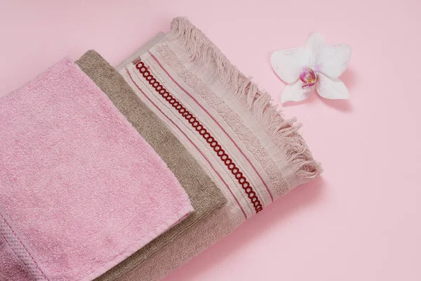 Soft terry towels with flower on pink background. — Stock Photo, Image