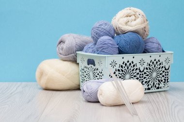 Örgü örmek için yün iplik. Doğal yün yumakları ve örgü iğneleri.