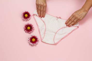 Pembe arka planda güzel külotlu kadın elleri..