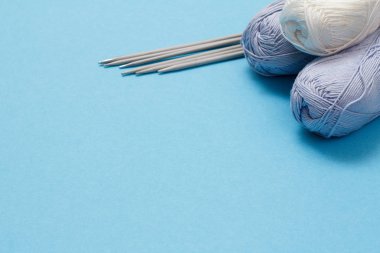 Örgü örmek için yün iplik. Doğal yün yumakları ve örgü iğneleri.