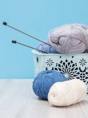 Örgü örmek için yün iplik. Doğal yün derileri ve örgü iğneleri.