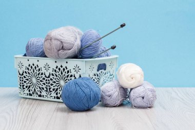 Örgü örmek için yün iplik. Doğal yün derileri ve örgü iğneleri.