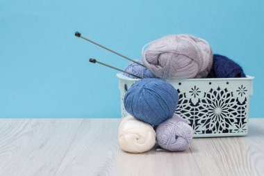 Örgü örmek için yün iplik. Doğal yün derileri ve örgü iğneleri.