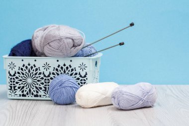 Örgü örmek için yün iplik. Doğal yün derileri ve örgü iğneleri.