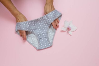 Pembe arka planda güzel külotlu kadın elleri..