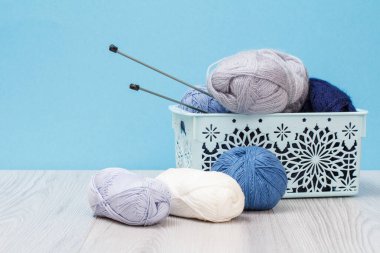 Örgü örmek için yün iplik. Doğal yün derileri ve örgü iğneleri.