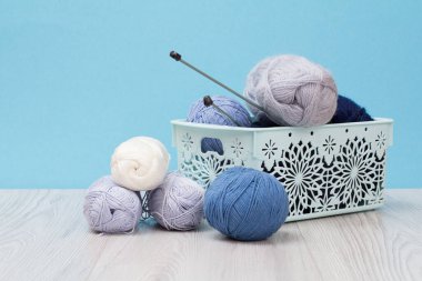 Örgü örmek için yün iplik. Doğal yün derileri ve örgü iğneleri.