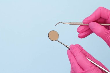 Dişçinin elleri sonda ve ağız aynasıyla.