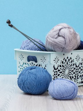 Örgü örmek için yün iplik. Doğal yün yumakları ve örgü iğneleri.