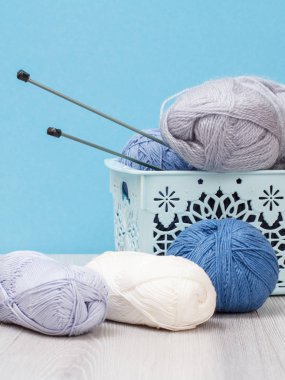 Örgü örmek için yün iplik. Doğal yün yumakları ve örgü iğneleri.