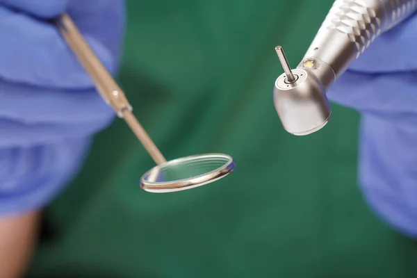 Tandläkarens händer i handske med dentalt handtag och munspegel. — Stockfoto