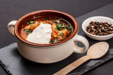 Siyah arka planda tahta kaşıkla Ukrayna geleneksel borsch 'u.