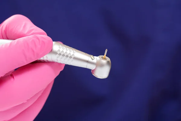 Tandläkarens hand i handske med dentalt handstycke. — Stockfoto
