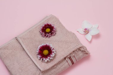 Pembe arka planda çiçekli yumuşak terli havlu.