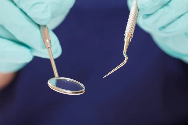 Mãos de dentista com sonda e espelho bucal . — Fotografia de Stock