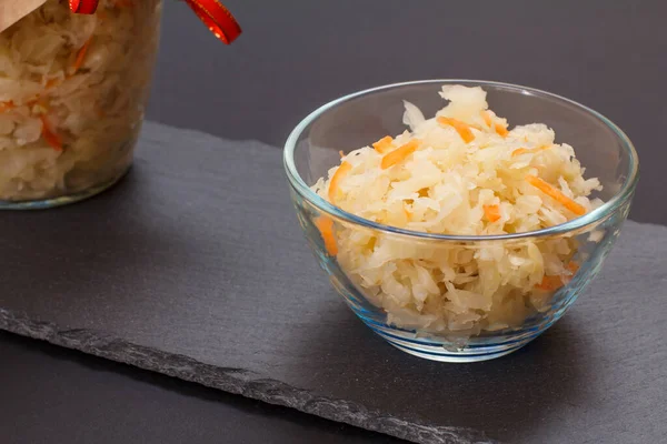 Fermented cabbage with herbs and spices in glass bowl on the black background — Stock Photo, Image