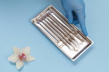 Diş bakımı için metal diş aletleri seti olan bir dişçi eli.