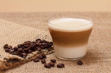 Kahve kapuçino ve çuval bezinde kahve çekirdekleri.