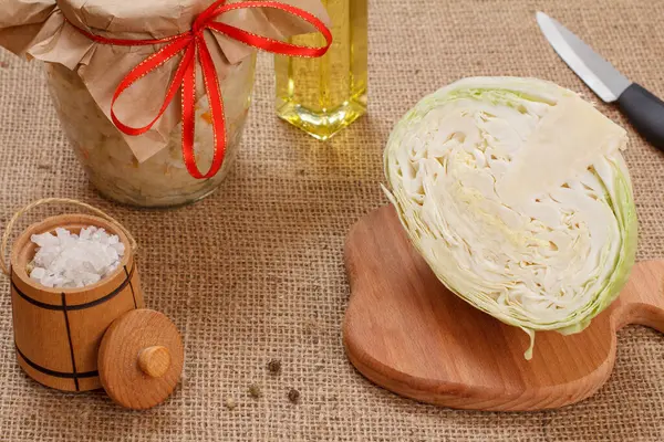 Fermented cabbage with herbs and spices in glass jar on the sackcloth — Stock Photo, Image