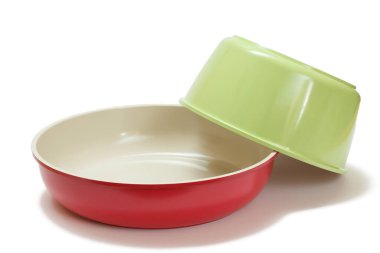 Kırmızı ve yeşil seramik mutfak tavaları beyaz izole arka planda.