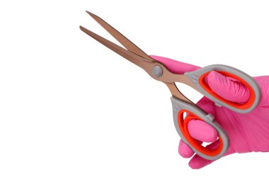 Beyaz arka planda izole edilmiş, elinde makas tutan pembe lateks eldivenli kadın eli.