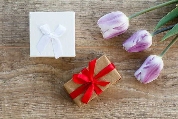 상자에 리본에 아름다운 라일락 튤립을 도마에 위에서 축일에 선물을 한다는 — 스톡 사진