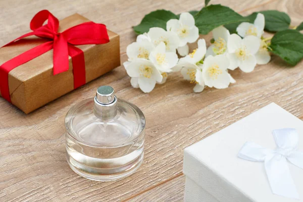 木製ボード上の香水 ギフトボックスとジャスミンの花の枝のボトル 休日に贈り物をするという概念 トップ表示 — ストック写真