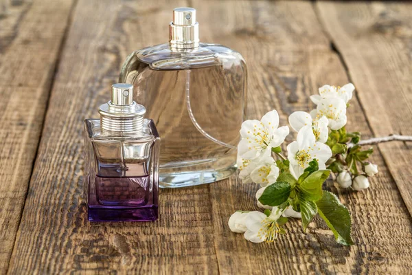 木製の背景に美しいジャスミンの花の枝と香水のボトル 休日に贈り物をするという概念 — ストック写真