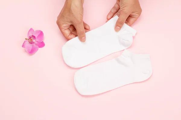 Dámské Ruce Bílými Ženskými Ponožky Růžovém Pozadí Pohled Shora — Stock fotografie
