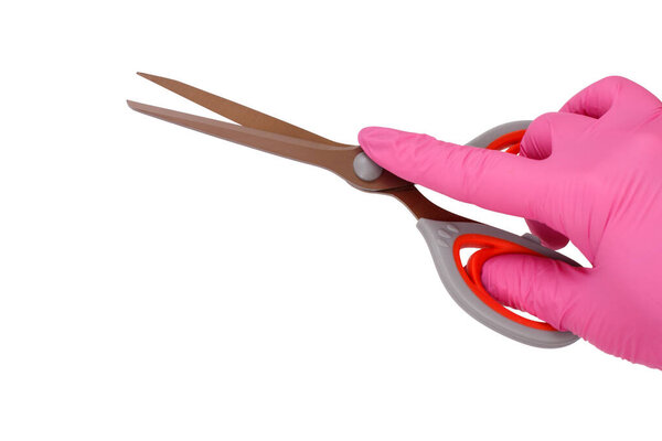 Female hand in pink latex glove holding scissors on white isolated background.