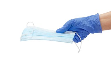 Mavi lateks eldivenli kadın doktor elinde tıbbi koruyucu bir maske tutuyordu. Viral enfeksiyonlara karşı kişisel koruma ekipmanları.