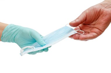 Lateks eldivenli kadın doktor bir hastaya tıbbi koruyucu maske veriyor. Beyaz soyutlanmış arka plan. Viral enfeksiyonlara karşı kişisel koruma ekipmanları.