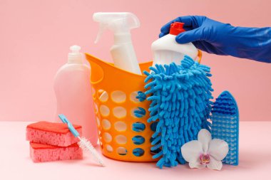 Kadın eli plastik eldiven içinde bulaşık deterjanı, cam ve fayans temizleyicisi mikrodalga fırın, fırın, bez, fırça ve sünger. Yıkama ve temizleme seti.