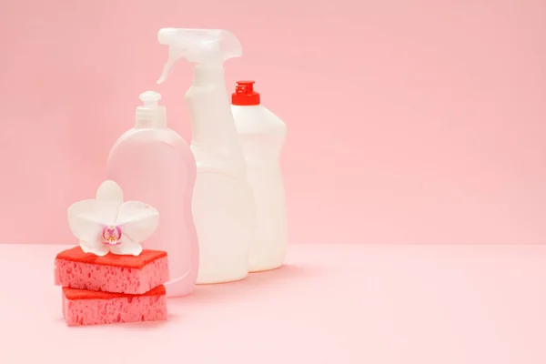 食器洗浄液 ガラスとタイルクリーナー 電子レンジやストーブ ピンクの背景にスポンジや白蘭の花のための洗剤のプラスチックボトル 洗浄セット — ストック写真