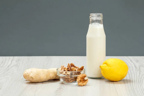 Health remedy relief foods and drink for cold and flu with lemon, ginger and walnuts on wood boards. Foods That Boost the Immune System.