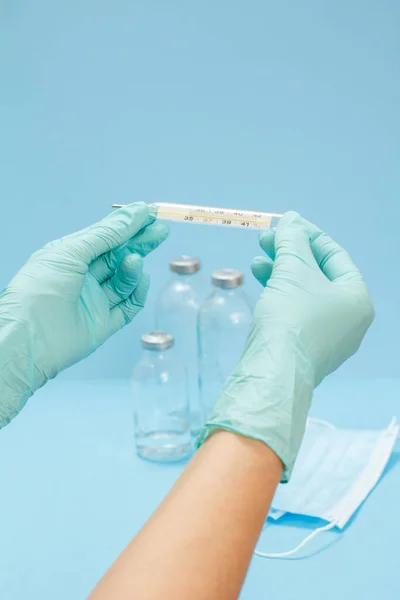 Doctora Guantes Látex Azul Sosteniendo Termómetro Mercurio Vidrio Con Botellas — Foto de Stock