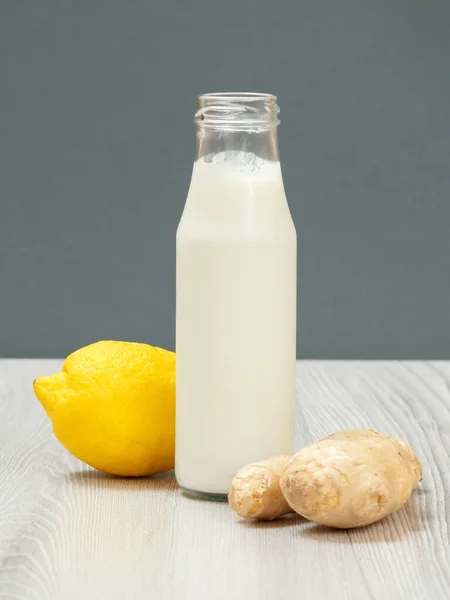 Health remedy relief foods and drink for cold and flu. Bottle of yogurt with a lemon and a ginger on wood boards. Foods That Boost the Immune System.