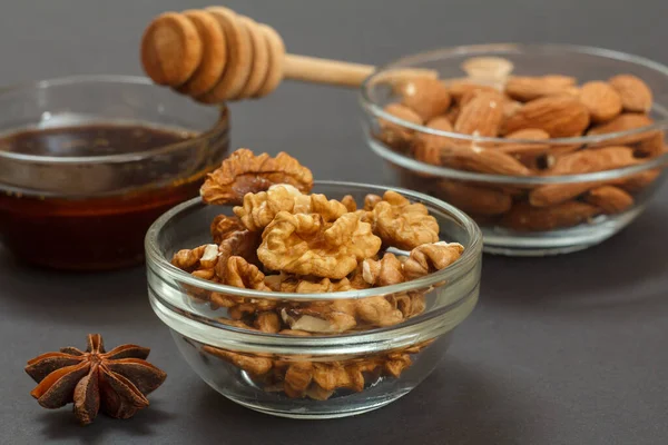 Health remedy foods for cold and flu relief with nuts, honey and a star anise on the black background. Foods That Boost the Immune System.