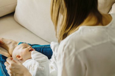 Genç anne ile kanepede küçük bir bebek. Onlar mutlular