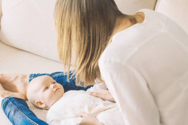 Genç anne ile kanepede küçük bir bebek. Onlar mutlular