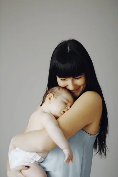 Um bebé a dormir nos braços da mãe. criança bonito, mãe feliz — Fotografia de Stock