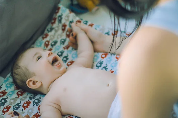 Mãe amorosa entretém bebê deitado na fralda — Fotografia de Stock