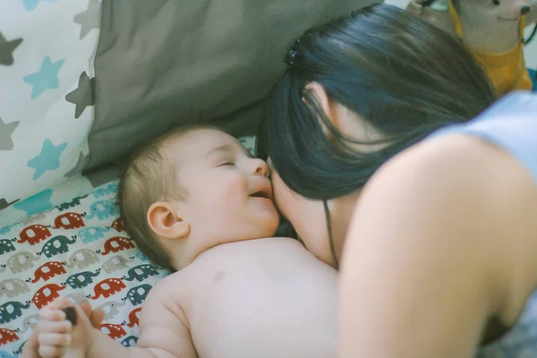 Mãe amorosa entretém bebê deitado na fralda — Fotografia de Stock