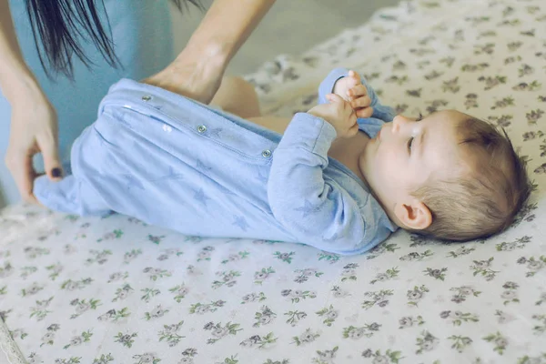 Mother puts a child in the body. it lies on diaper — Stock Photo, Image