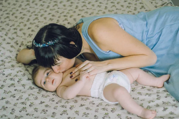 慈爱的母亲，与她在床上的婴儿 — 图库照片