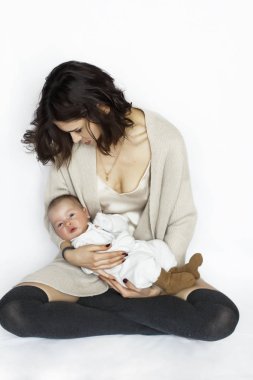 bir çocuk annesinin kollarında. Anne modaya uygun giyinmiş. İpek jersey. 