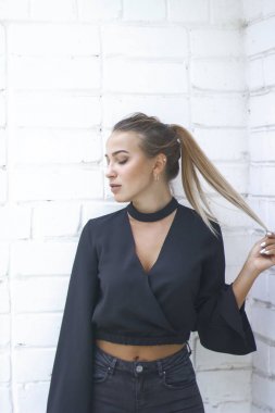 Bir kız ile yüksek bir kuyruk, o parmaklarını saç tutar. 